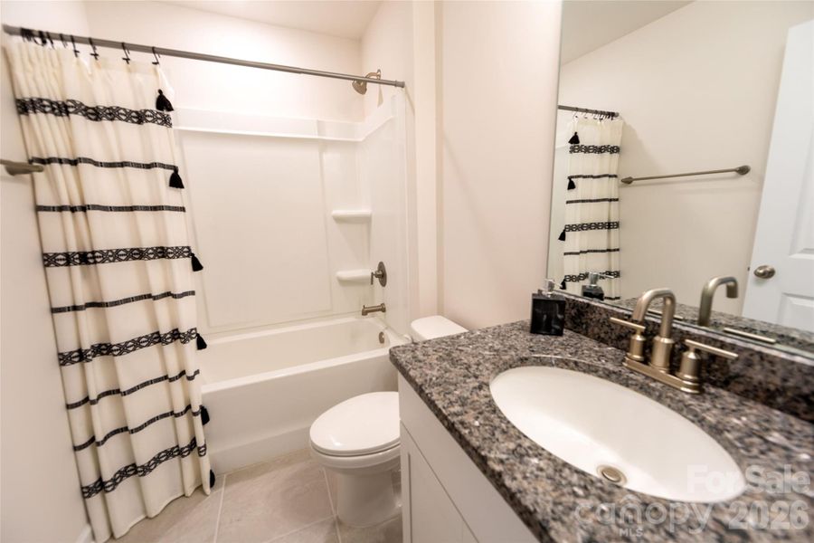 Upper-level bathroom with a combined tub and shower for convenience.