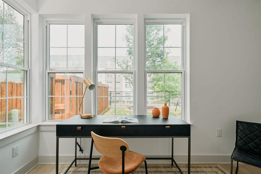 Triple pane windows with grid details, light wood-finish flooring, and crisp white wall paint Triple pane windows with grid details, light wood-finish flooring, and crisp white wall paint