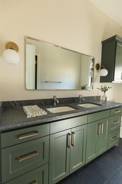 Full bathroom featuring double vanity and dark tile patterned floors