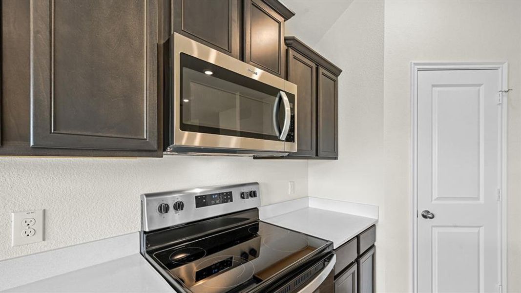 Kitchen with stainless steel appliances and dark wood finish cabinetry