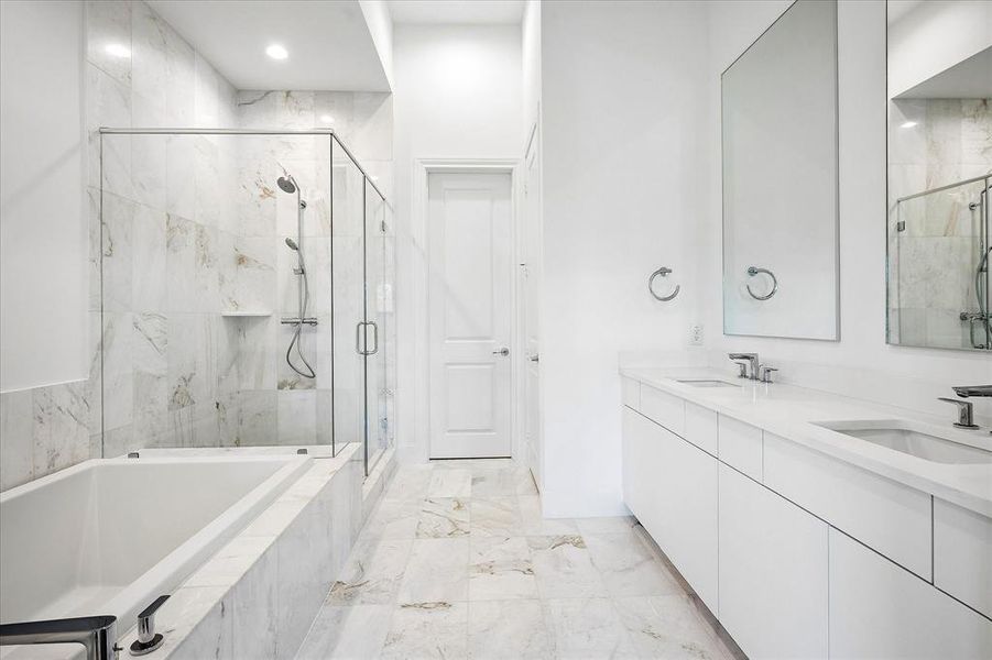 Bathroom featuring a full-length tub, glass-enclosed shower, dual vanity with undermount sinks, and tiled flooring Bathroom featuring a full-length tub, glass-enclosed shower, dual vanity with undermount sinks, and tiled flooring
