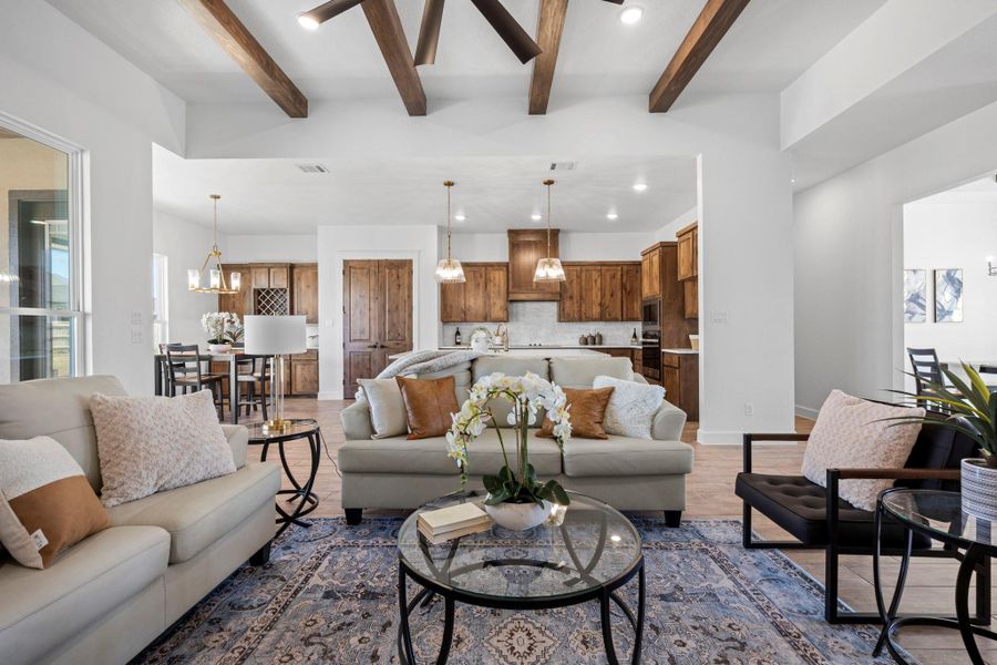 Living room featuring hanging lights, beamed ceiling, and wood finished floors