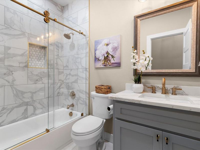 Full bath featuring combined bath / shower with glass door and vanity