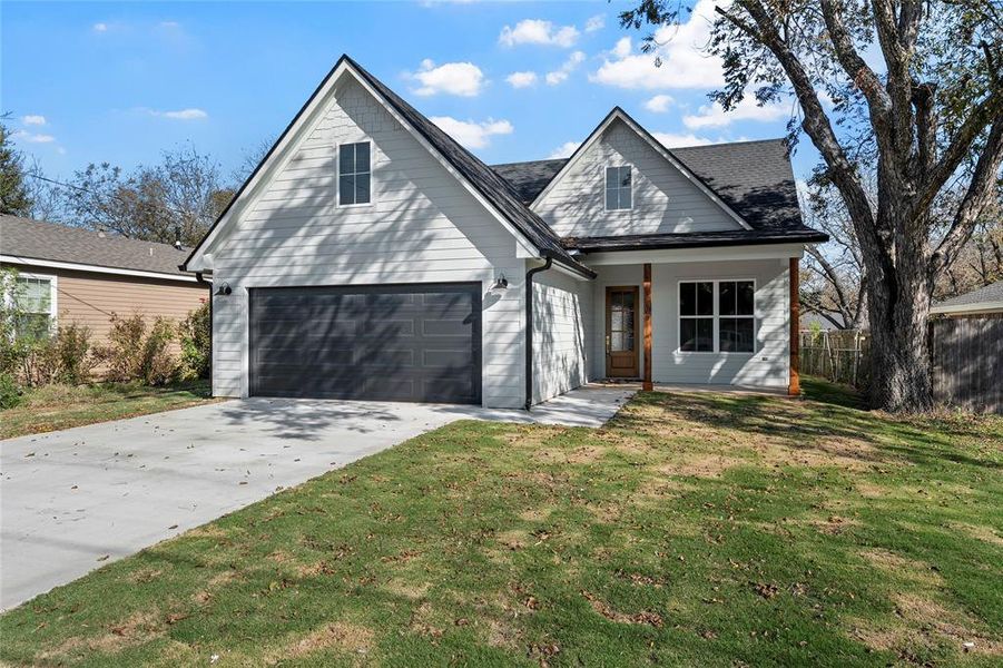 Traditional home with a garage, driveway, and covered porch Traditional home with a garage, driveway, and covered porch