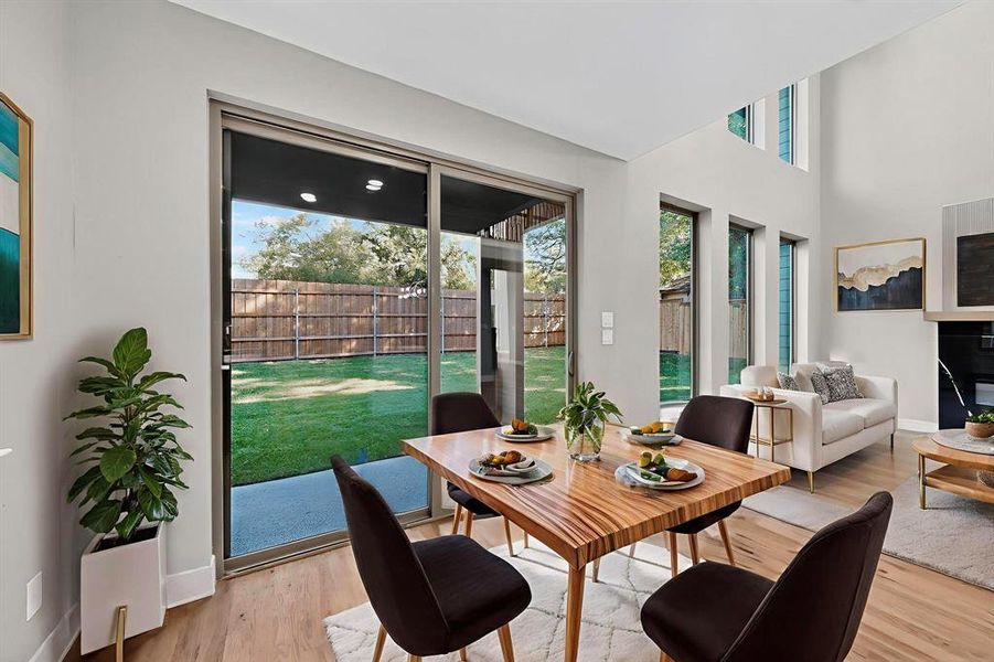 Dining space with wood finished floors and a towering ceiling