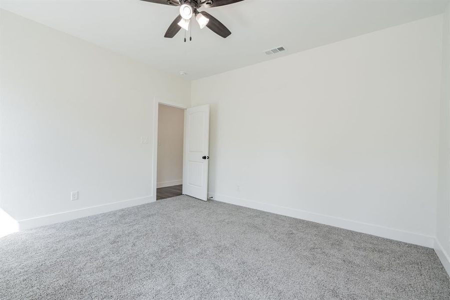 Spare room with ceiling fan and carpet flooring