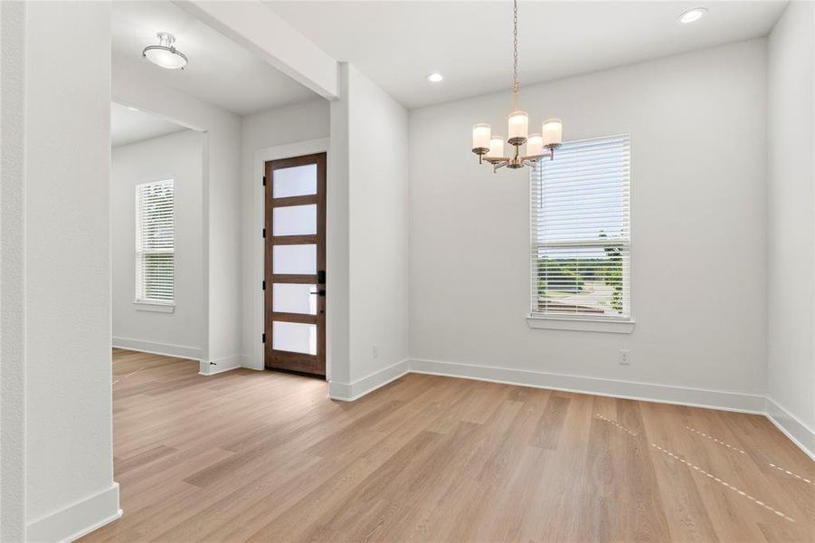 Unfurnished dining area with light wood-style flooring, a chandelier, and recessed lighting Unfurnished dining area with light wood-style flooring, a chandelier, and recessed lighting