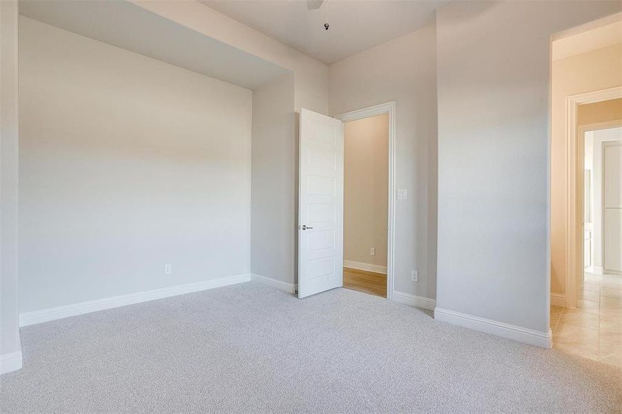 Unfurnished room featuring ceiling fan and light carpet