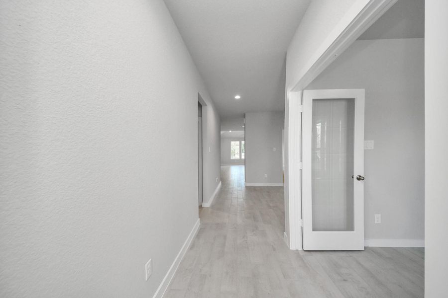 As you step into the threshold of this luxurious home, you'll soon be welcomed by an elegant glass door (to be installed). Inside, soaring ceilings amplify the spaciousness, while the refined wood-look tile flooring and oversized baseboards exude sophistication and charm. Sample photo of completed home with similar floor plan. Actual colors and selections may vary.