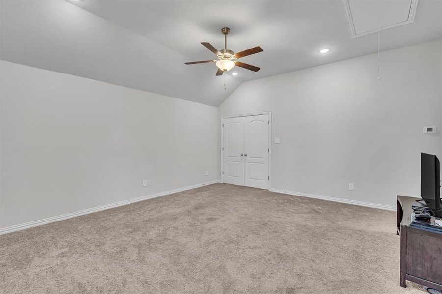 Unfurnished living room featuring carpet flooring, lofted ceiling, and ceiling fan