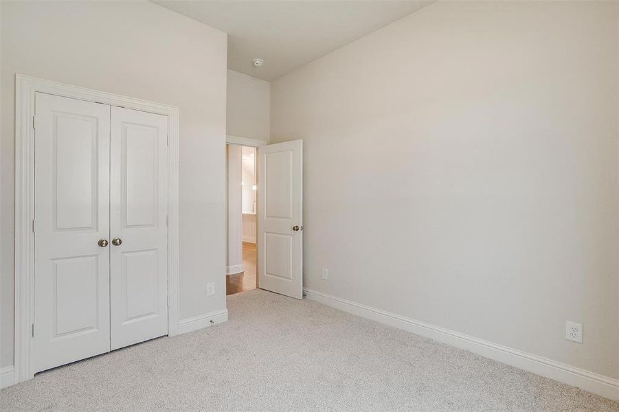 Unfurnished bedroom featuring a closet and light colored carpet