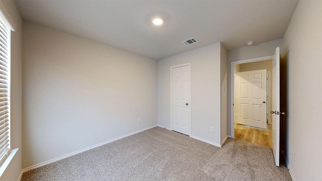 A well-proportioned bedroom with ample natural light from the window.