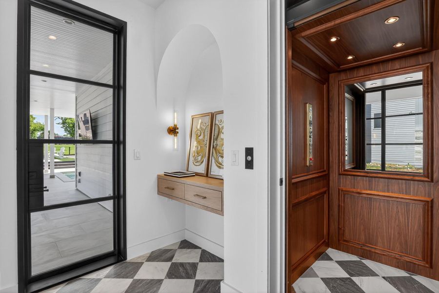 A private residential elevator with richly paneled walls and a window offers convenient access to multiple levels. A private residential elevator with richly paneled walls and a window offers convenient access to multiple levels.