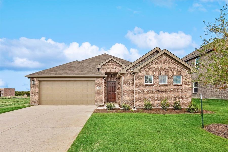 View of front of property featuring a front yard and a garage