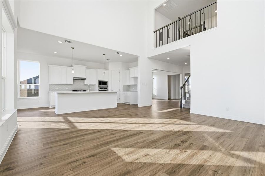 Unfurnished living room featuring dark wood-style flooring and recessed lighting Unfurnished living room featuring dark wood-style flooring and recessed lighting