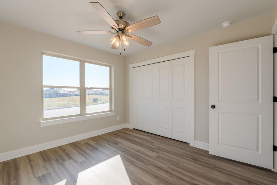 Unfurnished bedroom with light wood-style floors, a closet, and ceiling fan