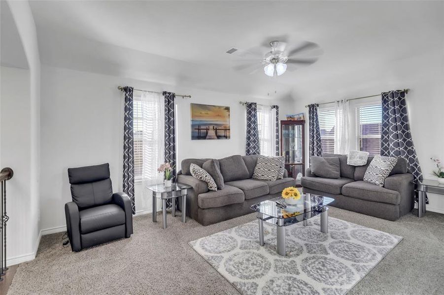 Living room with ceiling fan and light colored carpet