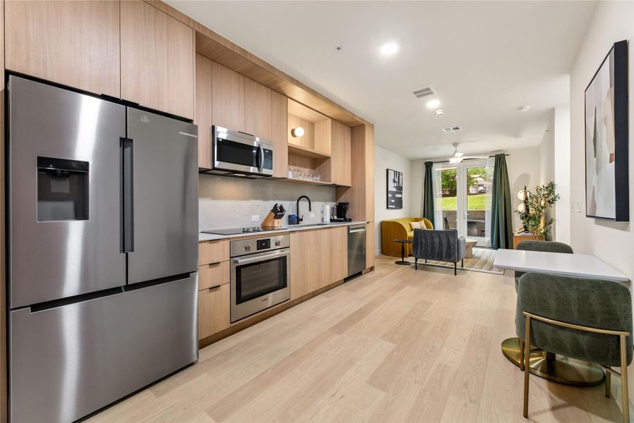 Modern cabinetry and integrated stainless appliances flow seamlessly into an open-plan living environment.