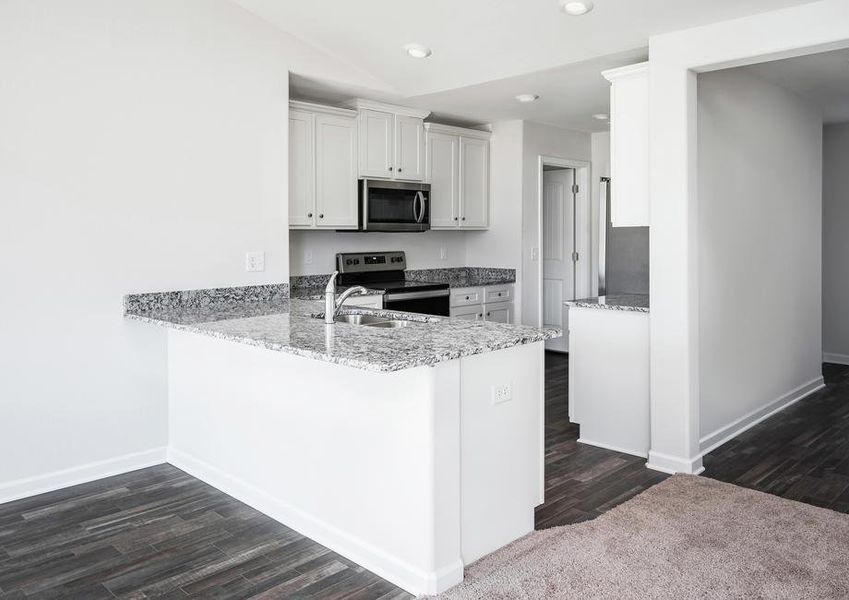 Kitchen with granite countertops, white cabinets and stainless steel appliances.