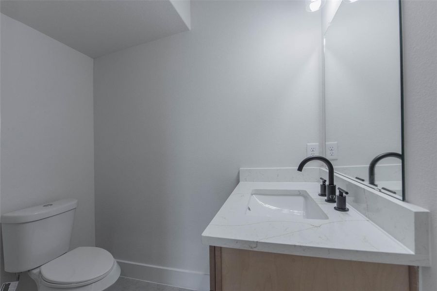 The powder room is conveniently located just off the living room and features quartz countertops and a stylish vanity, offering a bright and functional space. The powder room is conveniently located just off the living room and features quartz countertops and a stylish vanity, offering a bright and functional space.