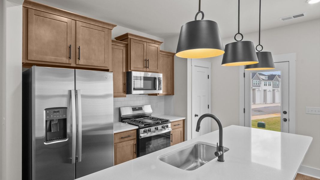 First-class kitchen with a spacious 9-foot island—perfect for entertaining beneath designer pendant lighting First-class kitchen with a spacious 9-foot island—perfect for entertaining beneath designer pendant lighting