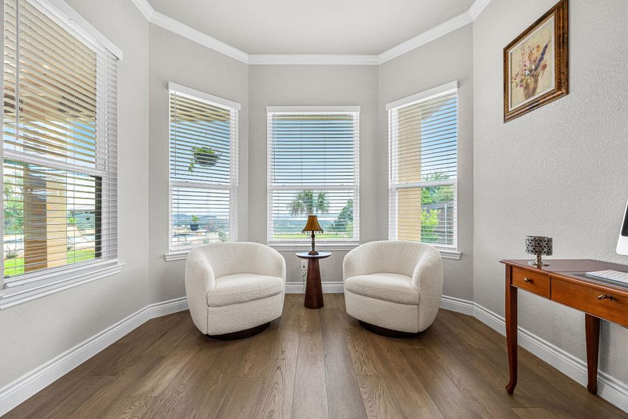 A well-lit sitting area with wide windows frames a tranquil view of the outdoors. A well-lit sitting area with wide windows frames a tranquil view of the outdoors.