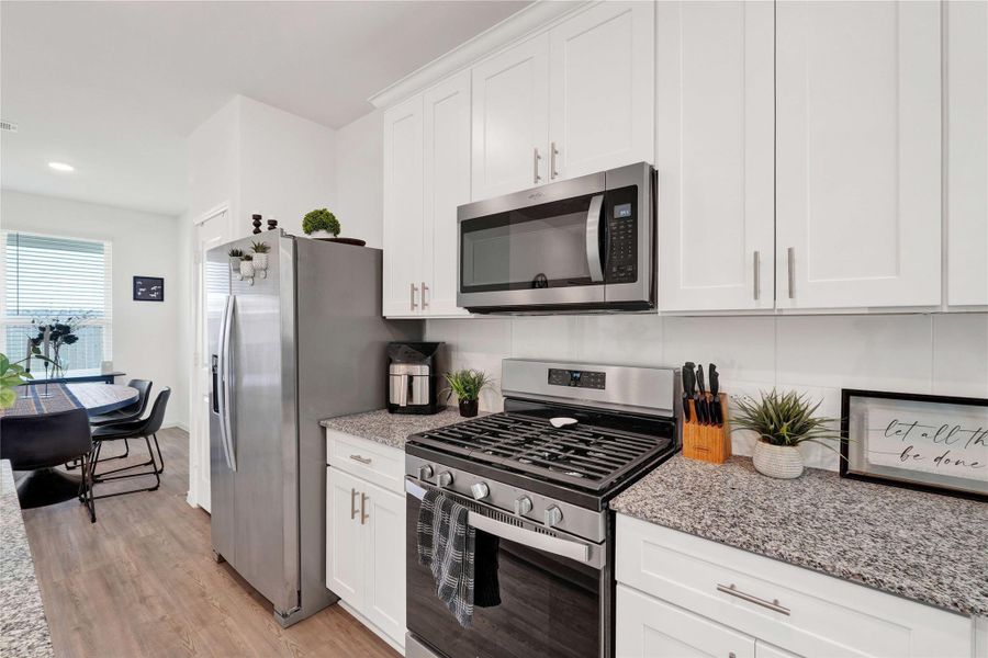 Fall in love with a modern chef’s kitchen featuring stainless-steel appliances, sleek cabinetry, ample counter space, and a large breakfast bar, creating a perfect balance of beauty and functionality.