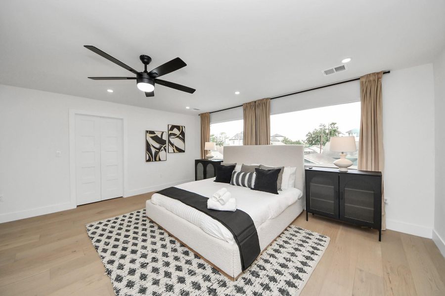 Spacious primary suite with oversized picture windows and a ceiling fan. Through the double doors is a massive 10x18 closet just waiting to be customized. Spacious primary suite with oversized picture windows and a ceiling fan. Through the double doors is a massive 10x18 closet just waiting to be customized.