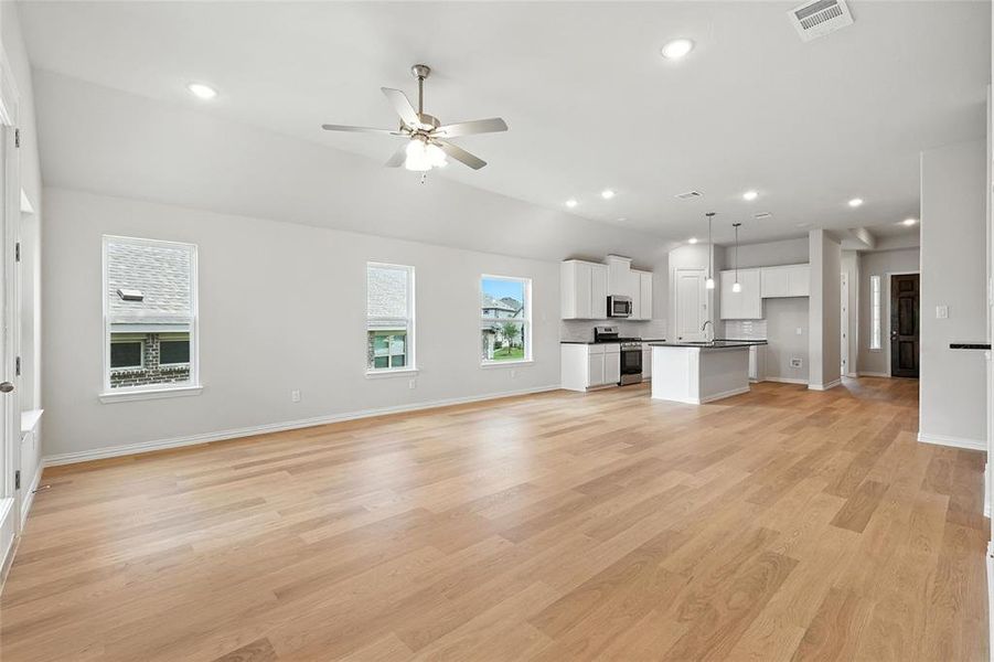 Unfurnished living room with ceiling fan, recessed lighting, and light wood finished floors Unfurnished living room with ceiling fan, recessed lighting, and light wood finished floors
