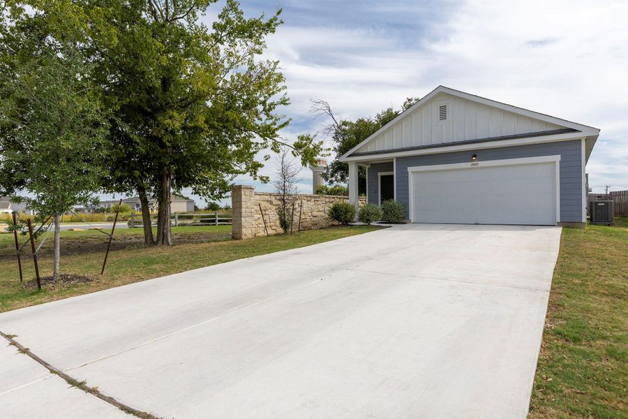 Single story home with board and batten siding, a garage, and driveway Single story home with board and batten siding, a garage, and driveway