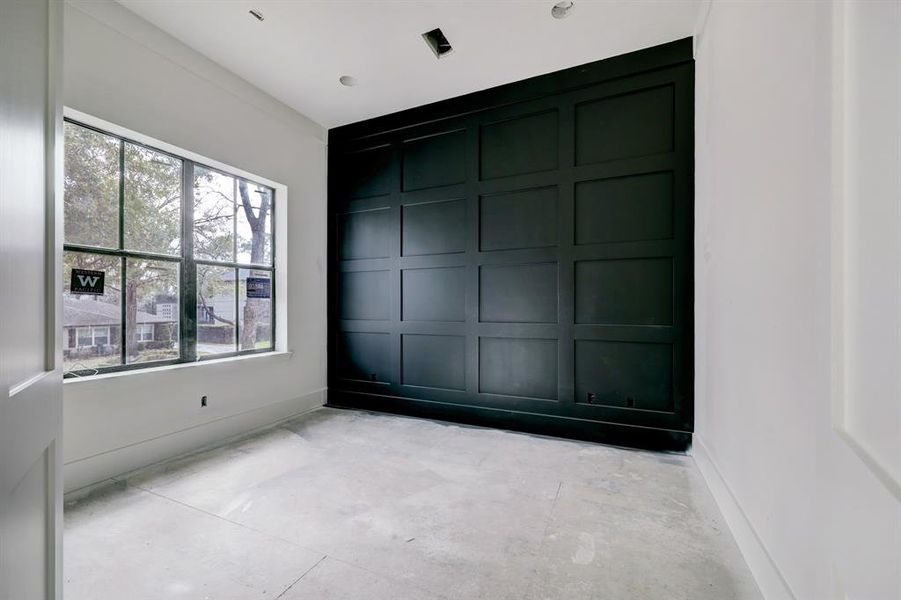 Study with paneled accent wall. Wood floors and beautiful gold chandelier to be installed.