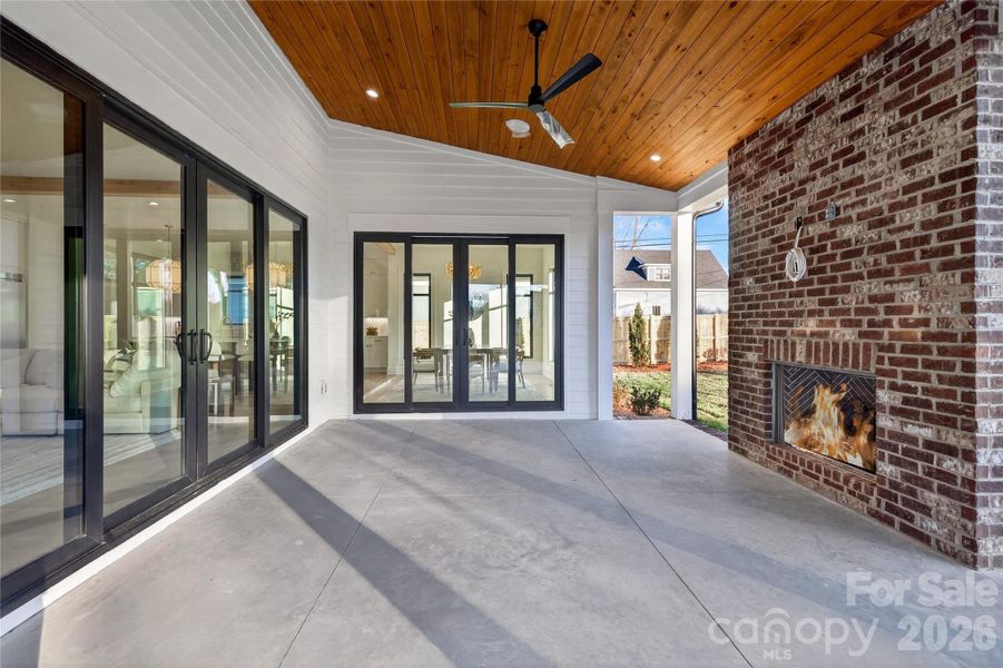Rear Porch. Concrete floor. Brick fireplace with gas logs. Rich wood ceiling, recessed lighting, ceiling fans.