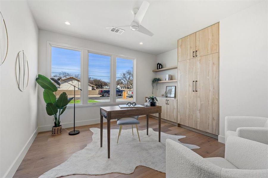 The second bedroom is located on the main floor, complete with hardwood flooring, built-in cabinets, and shelving.