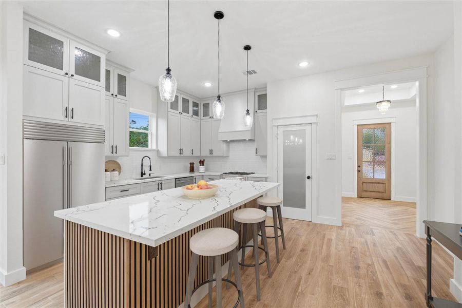 Filled with natural light, the kitchen boasts an open, spacious layout complete with a walk-in pantry and an oversized island.