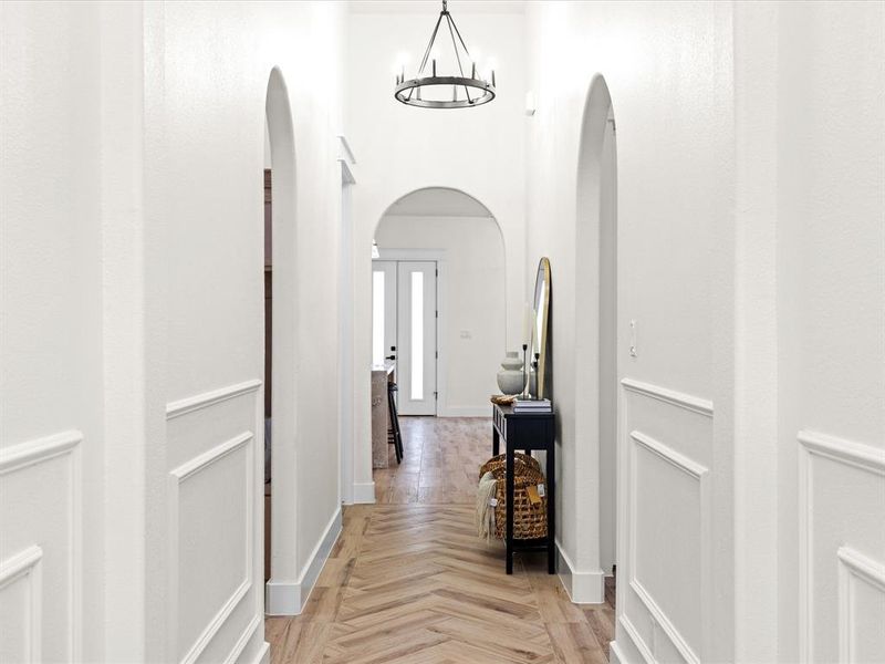 Corridor featuring a chandelier, french doors, and arched walkways