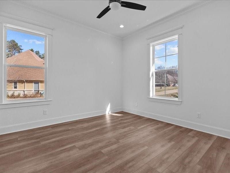 Spare room featuring crown molding, wood finished floors, and recessed lighting