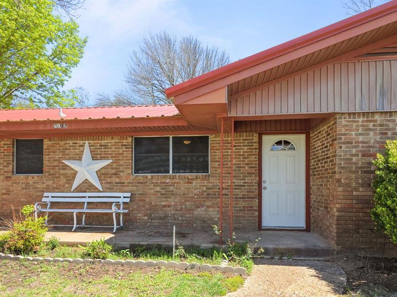 Property entrance with brick siding and metal roof Property entrance with brick siding and metal roof