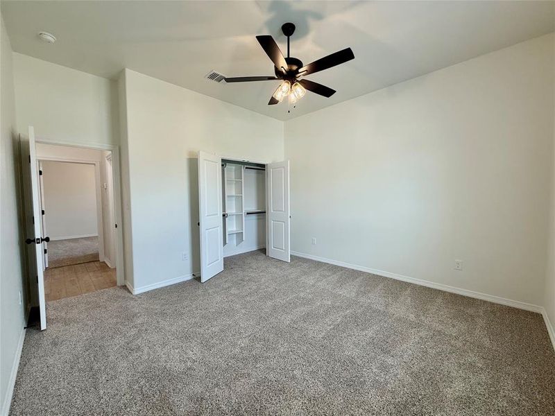 Unfurnished bedroom with carpet, a closet, and ceiling fan