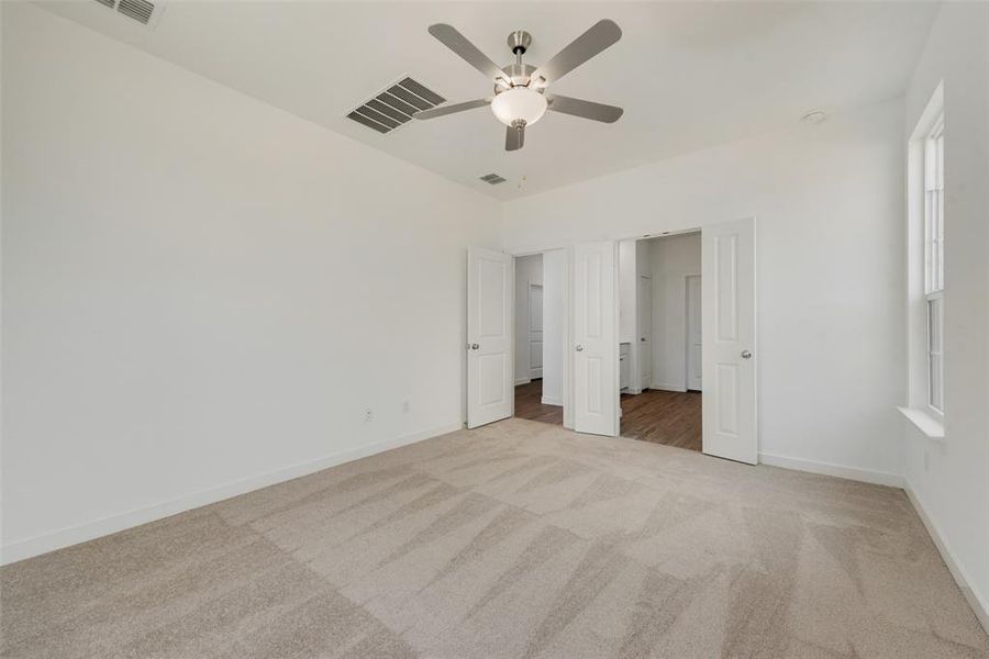 Unfurnished bedroom featuring light carpet and ceiling fan