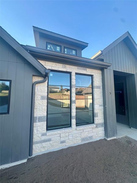 Doorway to property featuring stone siding and board and batten siding Doorway to property featuring stone siding and board and batten siding