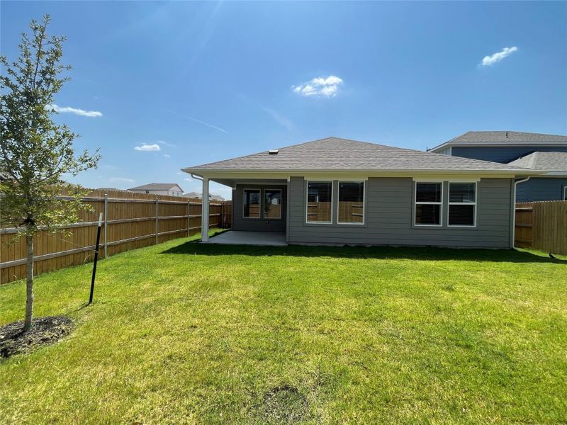 A fenced backyard with covered patio space for outdoor enjoyment.