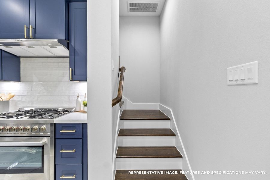 Tucked beside the kitchen, the stairs invite you upstairs after a long day, the dark wood steps contrasting beautifully against the crisp white walls.