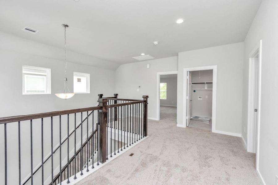 Come upstairs and enjoy a day of leisure in this fabulous game room! This is the perfect hangout spot or adult game room! Features plush carpet, high ceilings, custom paint and windows for plenty of natural light. Sample photo of completed home with similar floor plan. Actual colors and selections may vary.