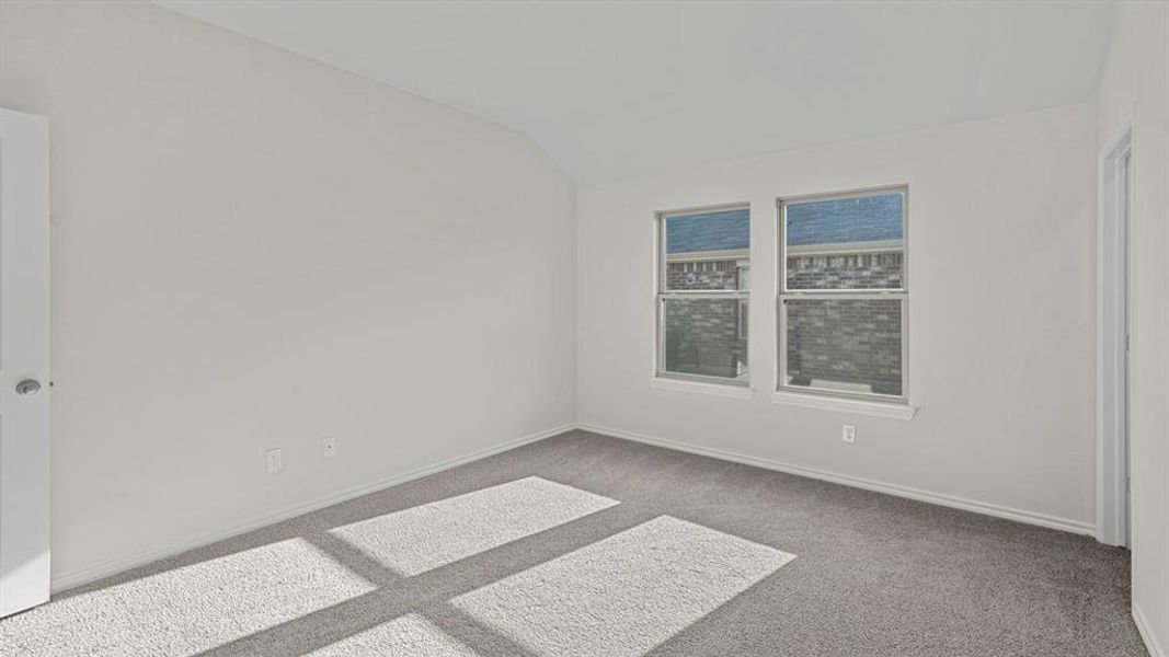 Unfurnished room with light carpet and vaulted ceiling