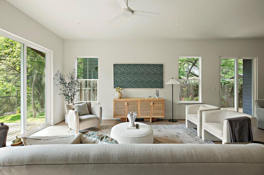 Living area featuring plenty of natural light, a ceiling fan, and wood finished floors