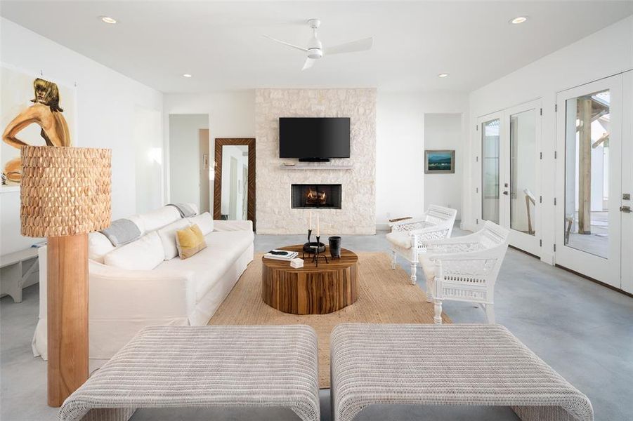 Living room with a stone fireplace and ceiling fan Living room with a stone fireplace and ceiling fan