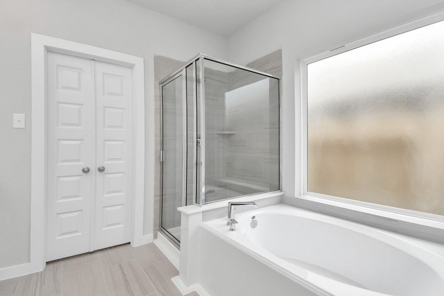 This additional view of the primary bath features a walk-in shower with the tile surround and separate garden tub perfect for soaking after a long day. This additional view of the primary bath features a walk-in shower with the tile surround and separate garden tub perfect for soaking after a long day.