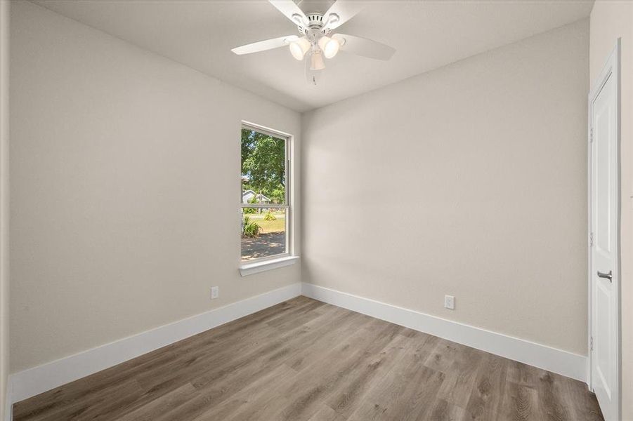 Empty room with ceiling fan and hardwood / wood-style floors