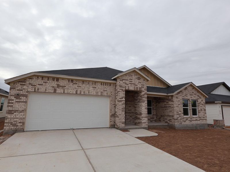 Front exterior of a new home in Carillon, Manor, TX, highlighting curb appeal (Image 8).