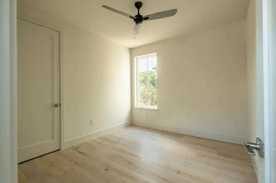 Natural light pours over light hardwood floors in this pristine bedroom. Natural light pours over light hardwood floors in this pristine bedroom.